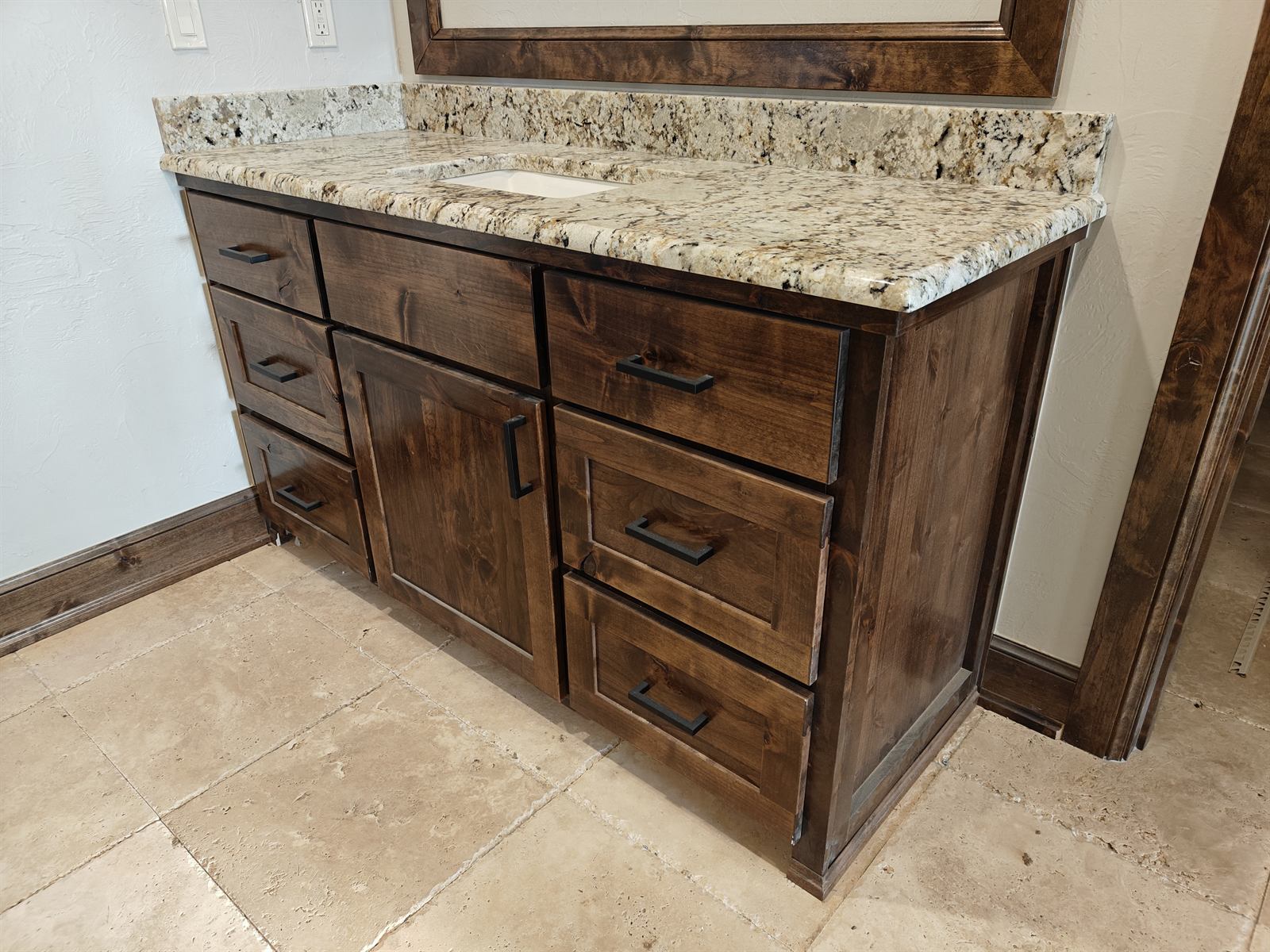 Custom dark-stained single-sink bathroom vanity with granite countertop