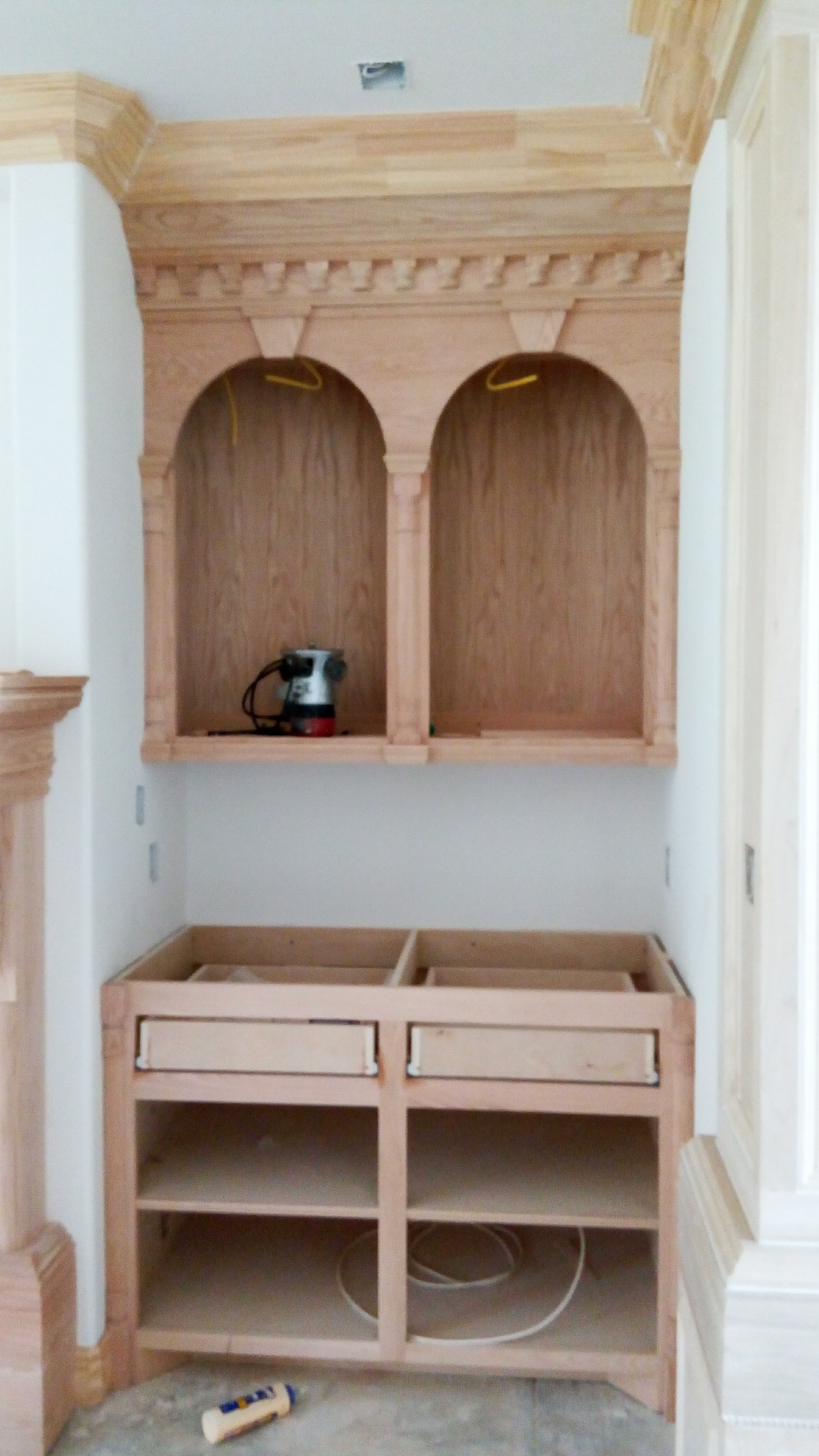 Unfinished custom built-in cabinet with arched niches